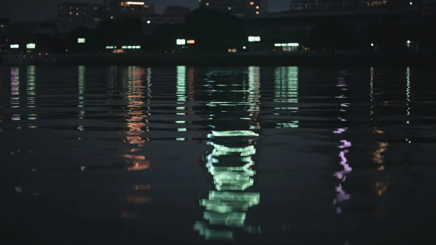 city lights reflecting on a river at night